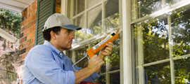 man caulking window